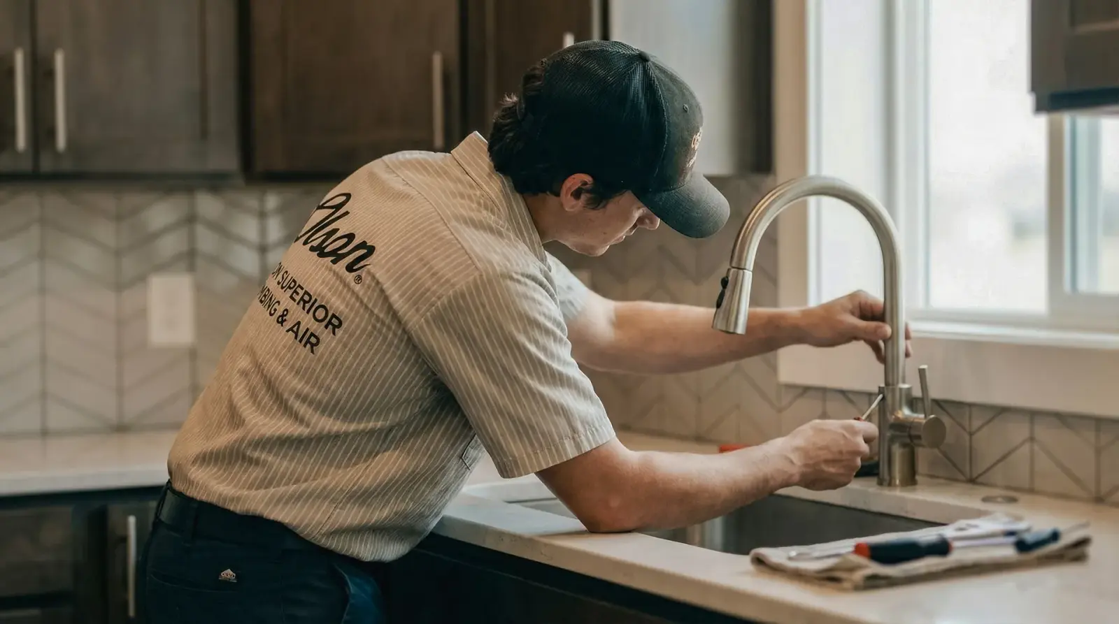 Olson Superior plumber performing a kitchen faucet repair in an Orange County home
